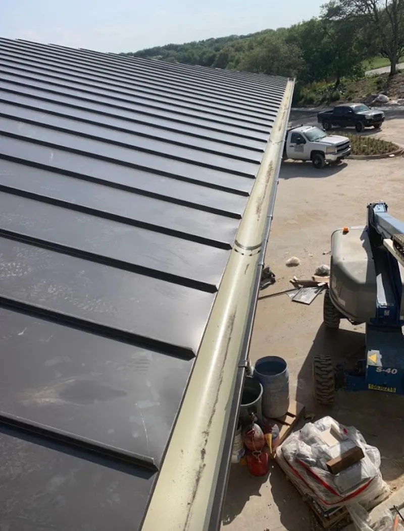 Standing seam panel and gutter detail on a metal roofing jobsite in Parkville